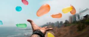 une main tendue vers des ballons