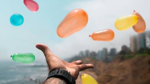 une main tendue vers des ballons