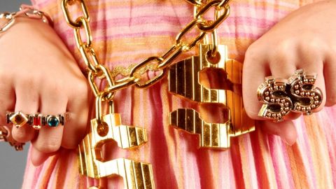 une fille avec des grosse bagues et des collier en or.