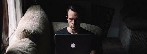 Les streameurs vont devoir rester chez eux. Un homme seul devant un ordinateur dans la pénombre