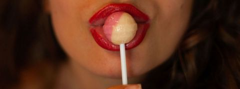 Une étude démonte l'idée reçue - le sexe fait vendre - Gros plan sur la bouche du femme avec du rouge à lèvres qui mange une sucette
