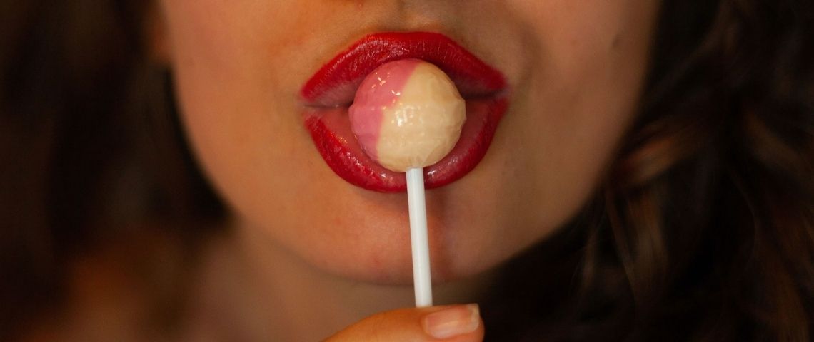 Une étude démonte l'idée reçue - le sexe fait vendre - Gros plan sur la bouche du femme avec du rouge à lèvres qui mange une sucette