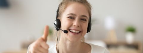 Télétravailleuse avec un casque lève le pouce