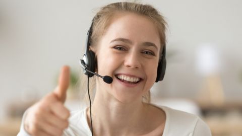 Télétravailleuse avec un casque lève le pouce