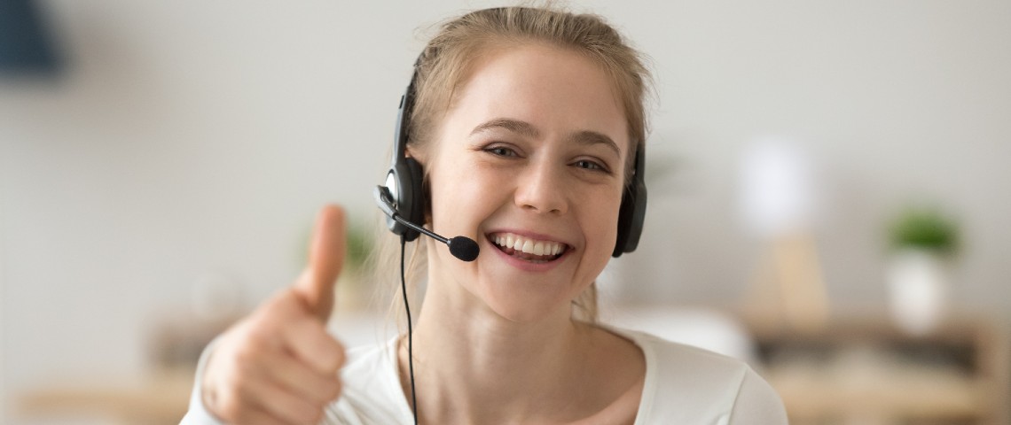 Télétravailleuse avec un casque lève le pouce