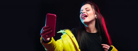 Le secret de TikTok pour nous garder plus longtemps une fille regarde son portable en tirant la langue