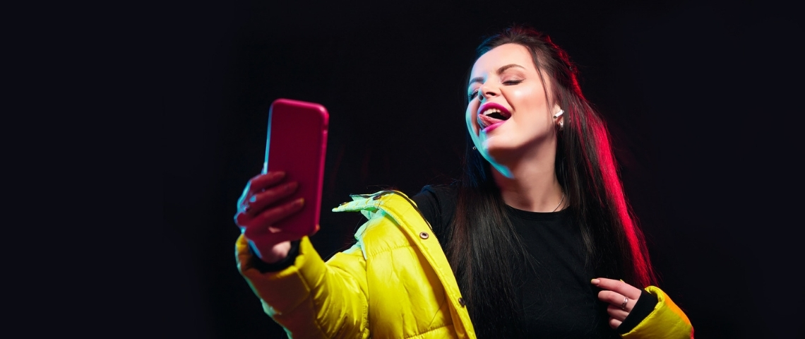 Le secret de TikTok pour nous garder plus longtemps une fille regarde son portable en tirant la langue