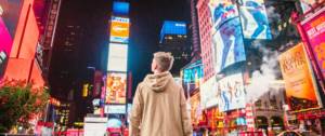 Adolescent de dos à Time Square, devant les affichages publicitaires lumineux