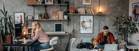 Top des outils pour mieux télétravailler Une femme et un homme en train de travailler dans un salon