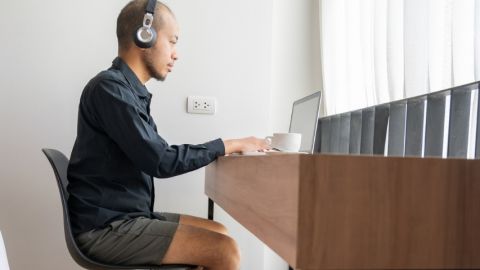 Un homme dans sa chambre d'hôtel en train de télétravailler