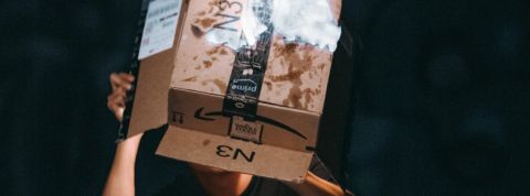 Amazon, le symbole de la colère du reconfinement Un homme tient un carton Amazon en train de brûler