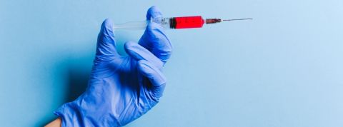 Les Français ne veulent pas se faire vacciner contre le coronavirus Une main gantée tenant une seringue remplie d'un liquide rouge