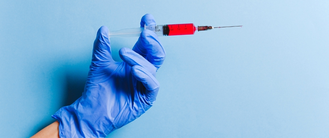 Les Français ne veulent pas se faire vacciner contre le coronavirus Une main gantée tenant une seringue remplie d'un liquide rouge
