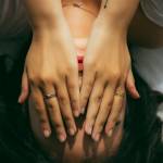 Une femme allongée sur son lit, se tenant le visage dans ses mains