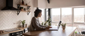 Une femme en train de télétravailler dans son appartement