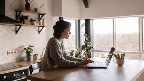 Une femme en train de télétravailler dans son appartement