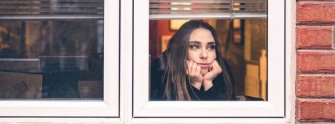 Que s'est-il passé pendant la deuxième semaine de reconfinement ? Une jeune femme regardant par la fenêtre