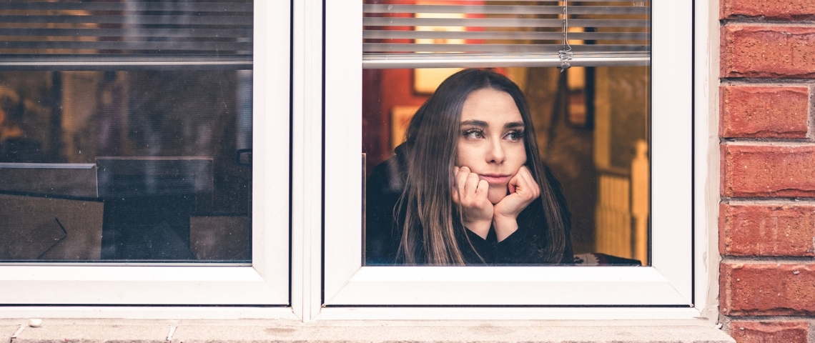 Que s'est-il passé pendant la deuxième semaine de reconfinement ? Une jeune femme regardant par la fenêtre
