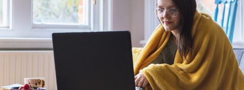 Que s'est-il passé pendant notre première semaine de reconfinement ? Une jeune femme, un plaid enroulé autour de ses épaules, sur son ordinateur