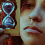 Une jeune femme s'ennuyant, tenant un sablier