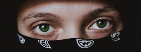 Comment le crime profite de la crise ? Un homme portant un bandana sur le visage en gros plan