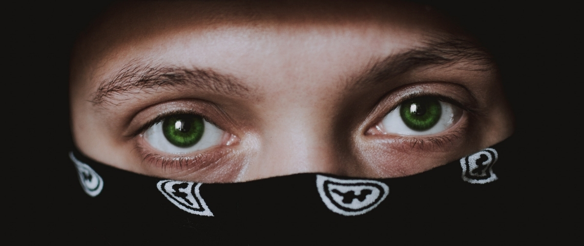 Comment le crime profite de la crise ? Un homme portant un bandana sur le visage en gros plan