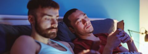 Pourquoi partager ses codes Netflix est une mauvaise idée (même avec sa moitié) Un couple dans un lit consulte smartphone