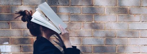 Confinement : Trois textes à lire pour éviter de céder aux idées faciles Une femme se cache le visage avec un livre