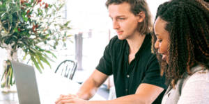 Que veulent les jeunes en entreprise ? Une jeune femme noire et un jeune homme blanc en train de travailler