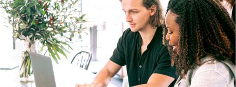 Que veulent les jeunes en entreprise ? Une jeune femme noire et un jeune homme blanc en train de travailler