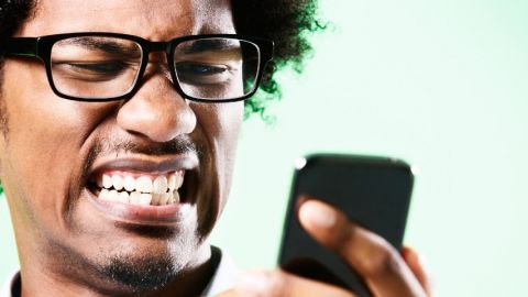 Un monsieur énervé devant son smartphone