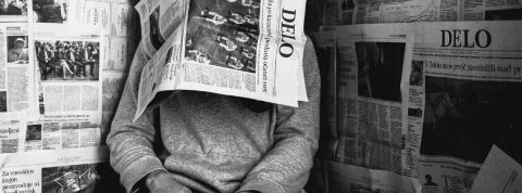 Trois textes à lire pour mieux vivre le reconfinement Homme avec un journal sur sa tête en noir et blanc