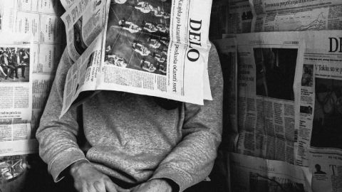 Homme avec un journal sur sa tête en noir et blanc