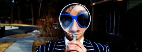 Les enquêteurs amateurs de Facebook Un homme en costume avec un loupe sur le visage