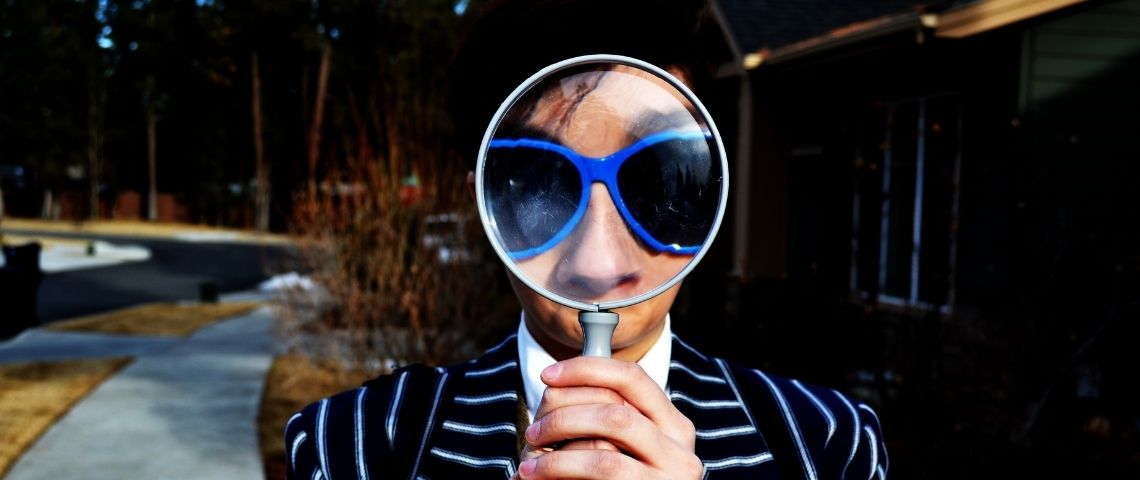 Les enquêteurs amateurs de Facebook Un homme en costume avec un loupe sur le visage