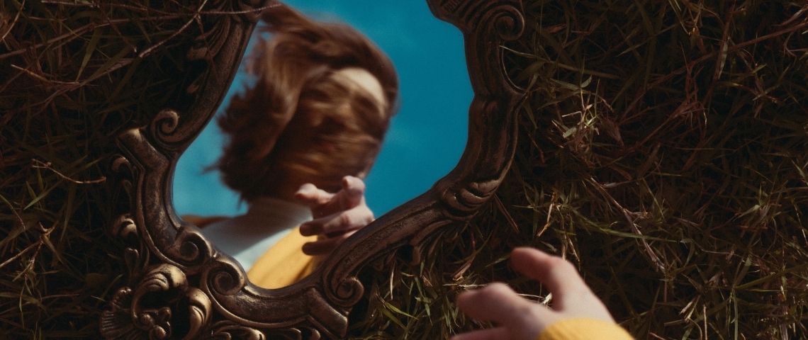 La tendance de la manifestation sur TikTok Une femme qui se regarde dans un miroir posé par terre