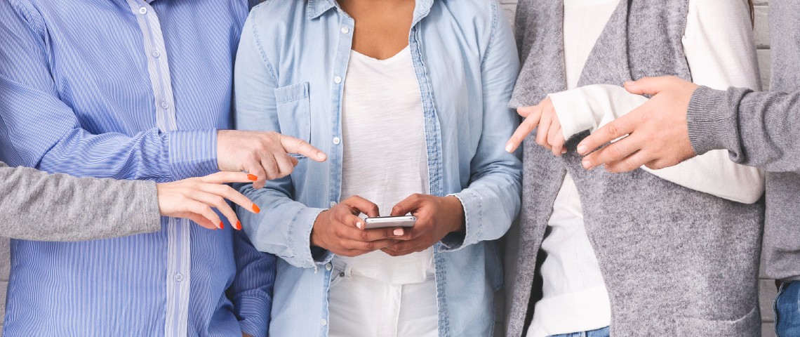Dark Social : la manipulation est passée de Facebook à WhatsApp Des personnes en train de pointer le smartphone d'une personne au centre d'un groupe