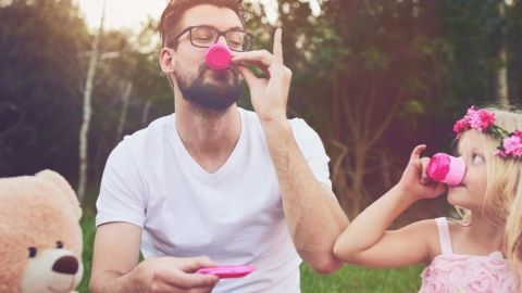 Un homme qui le thé avec une petite fille habillée en rose