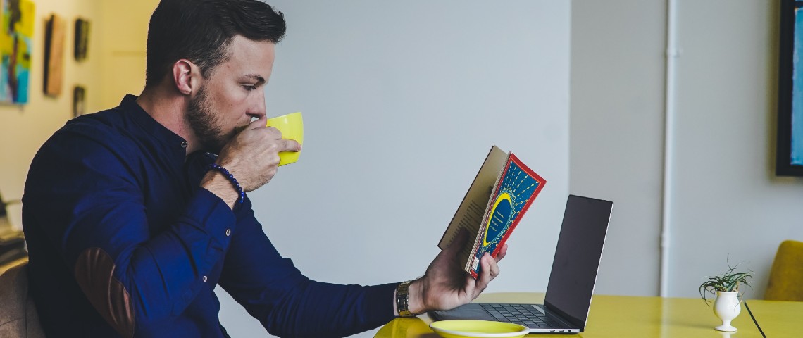 Trois textes pour réfléchir à l'omniprésence des technologies Un homme lit un livre devant son ordinateur portable