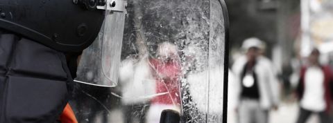 Un projet de loi liberticide ? derrière le bouclier transparent d'un policier.