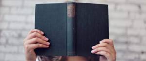 Une femme cachée derrière un livre