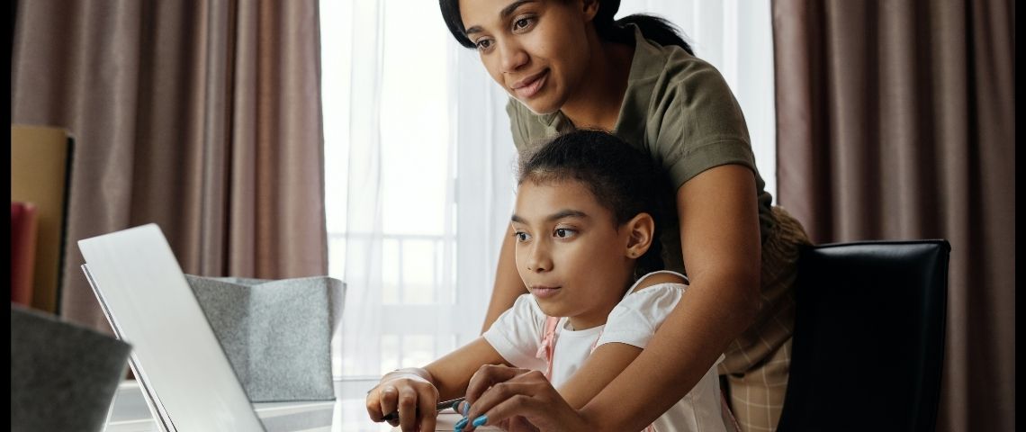 Les parents d'élèves font du zoom-bombing Une mère qui aide sa fille à faire ses devoirs devant l'ordinateur