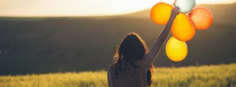 5 bonnes nouvelles pour égayer notre semaine Une femme tient 5 ballons dans la nature