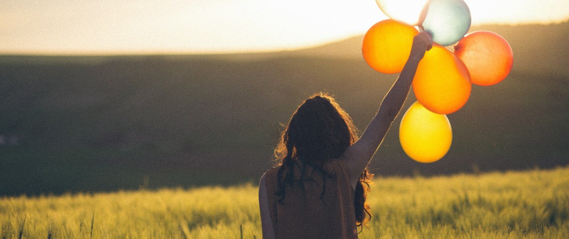 5 bonnes nouvelles pour égayer notre semaine Une femme tient 5 ballons dans la nature