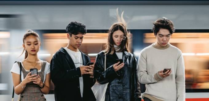 Quatre adolescents qui regardent leur téléphone portable