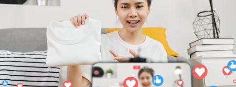 Pourquoi le live shopping ne décolle pas en France Une jeune femme fait un livestream shopping filmé par son smartphone