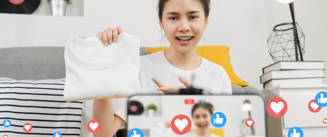 Une jeune femme fait un livestream shopping filmé par son smartphone