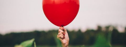 La résilience, le mot de l'année 2020 Une femme tient un ballon rouge, symbole de sa résilience