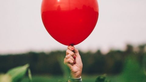 La résilience, le mot de l'année 2020 Une femme tient un ballon rouge, symbole de sa résilience