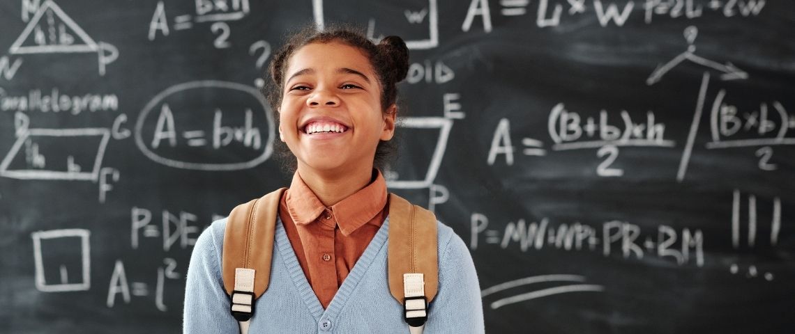 Acadomia accompagne un monde et une jeunesse qui changent avec l’agence Rosapark Jeune fille souriante devant un tableau d'école